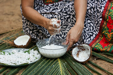 Obraz na płótnie Canvas Woman making homemade fresh thick coconut milk with grated coconut , squeezing with hand Kerala India Sri Lanka in Indian Kitchen. ingredient in Indian curry. vegan non dairy health drink.