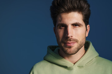 Obraz premium Pleased handsome man in sportswear posing and looking at camera