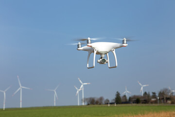 Drohne fliegt über Landschaft mit Windrädern