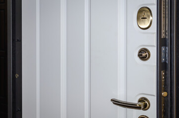 A metal door with a lock, sheathed in white wood.