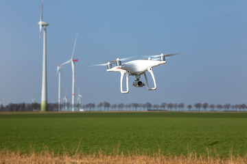 Drohne fliegt über Landschaft mit Windrädern