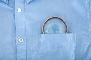 Close up magnifying glass in blue shirt pocket