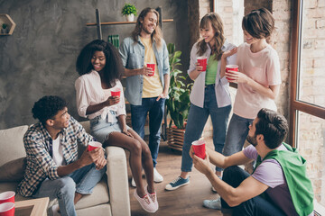 Photo portrait of friends spending time together drinking beer talking in hostel