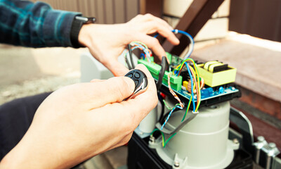 Technician man installing and checking the function of automatic gate