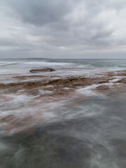 Fototapeta na wymiar Cloudy seascape view around rocky coastline.