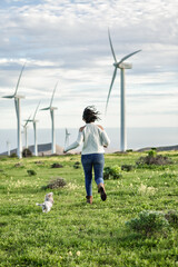 Woman running along field with dog in summer