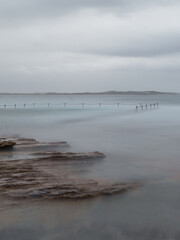 Rocky coastline and tidal pool view on a cloudy day.