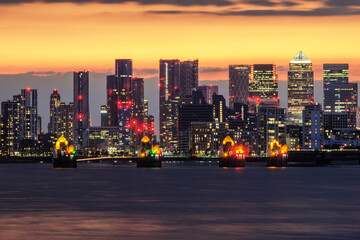 Thames Barrier in front of Canary Wharf at dusk, London, England, UK