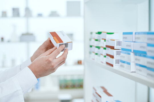image of a box of medicine in the hands of a pharmacist.