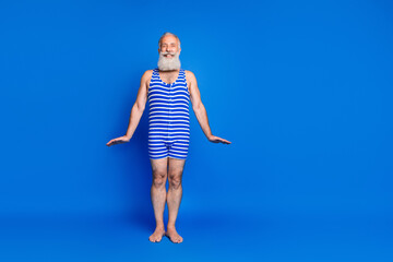Full length photo of cheerful elderly man wear bathing suit striped copyspace summer swim isolated...