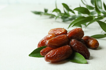 Dried dates and leaves on white textured background