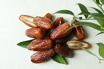 Dried dates and leaves on white textured background
