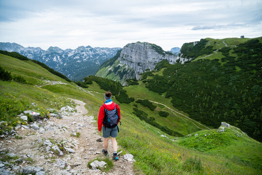 Rear view of a woman hiking along an alpine footpath in the Austrian Alps, Loser mountain region, Ausseerland, Austria - Powered by Adobe