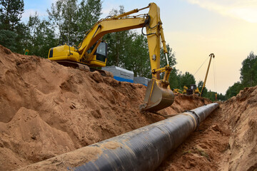 Natural Gas Pipeline Construction. Gas and Crude oil transmission in pipe from gas storage and plant development to facility.  Excavator and pipelayer during building of transit petrochemical pipes - obrazy, fototapety, plakaty