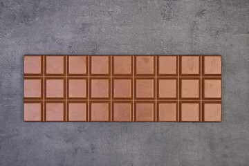 sweet delicious chocolate lies on dark gray stone background