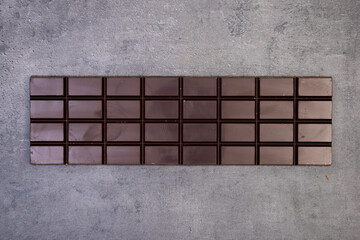 sweet delicious chocolate lies on dark gray stone background
