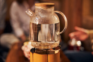 Fototapeta na wymiar Glass teapot with water on portable gas burner