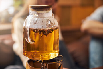 Glass teapot with herbal tea on portable gas burner