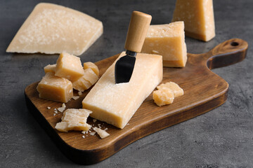 Parmesan cheese with knife on grey table