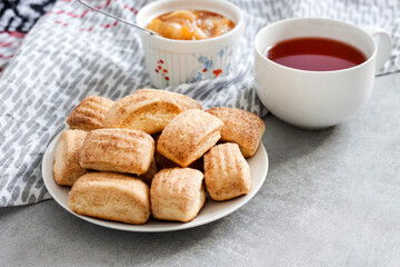 Tasty breakfast. Homemade sweet cinnamon cookies and cup of tea. Apple confiture on background