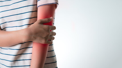 An Asian girl grabs her hand on her elbow.