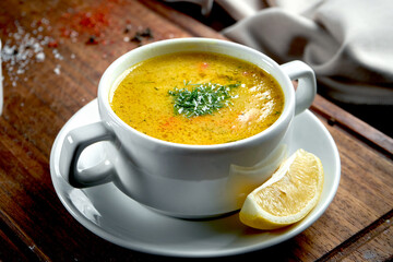 Oriental dish - a yellow lentil cream soup in white on a dark background piala