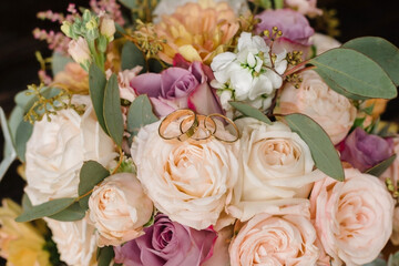 Wedding rings on the background of the bride's bouquet. Close-up. Soft focus.