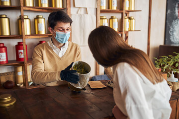 Charming young woman making purchases in tea shop