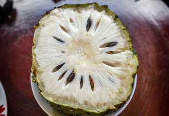 Soursop (also graviola, guyabano, and in Latin America, guanábana) on the plate. The fruit of...