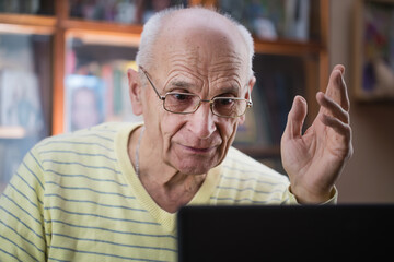 Retired elder man in glasses has online communication with family.
