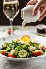 Greek salad with arugula, cream cheese, pine nuts, tomato, black olives and cucumber. healthy vegan lunch bowl. Food recipe background. Close up