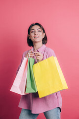Woman wearing casual sweater on background happy enjoying shopping holding colorful bags