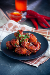 Red fried korean chicken on dark background