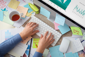 Overwhelmed woman working at messy office desk, above view