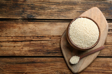 White sesame seeds on wooden table, top view. Space for text