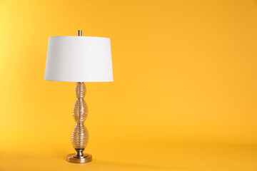 Stylish new night lamp on yellow background. Space for text