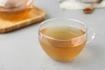 Glass cup of buckwheat tea on light grey table