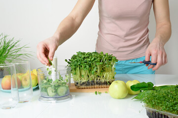 step-by-step recipe for making smoothies from micro-green apples cucumber and spinach. woman hands cut vegetables and put them in blender for whipping eco organic fresh food detox on light background