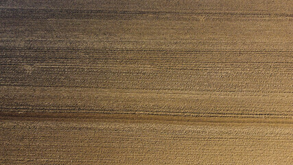 Arial drone view of freshly plowed field ready for seeding and planting in spring.  Farmland. Empty plowed farm land prepared for the new crop. Agriculture. Brown black soil near village.