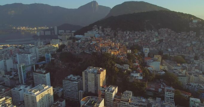 Aerial move towards Cantagalo hilltop favela set amongst luxury apartment buildings and Rio de Janeiro's natural mountains
