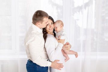 concept of a happy young family, lifestyle, parents holding a newborn baby in their arms