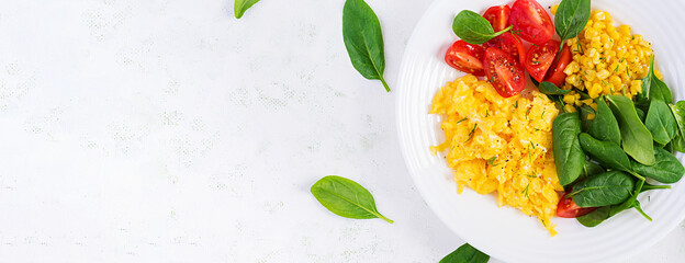 Breakfast. Scrambled eggs with cherry tomatoes, spinach  and corn. Top view,  banner