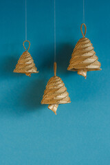Bells made out of straw on a blue background. Straw bells decorations.