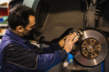 Mechanic repairing car brake pads. Vehicle repair concept.