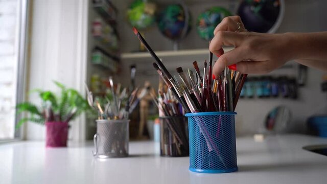 Woman choosing a brush for painting