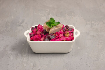 salad vinaigrette with herring on concrete background