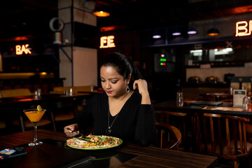 Portrait of a pretty woman eating delicious food in a restaurant.