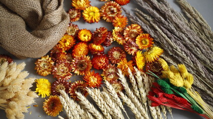 Kwiaty i trawy suche  z tkaniną jutową na szarym tle