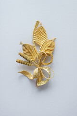 Boutonniere made out of straw on a white background. Brooch. Branch with flowers. Decor. The products are made of straw 