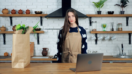 Woman housewife in beige apron looking camera prepare study online culinary webinar course in...